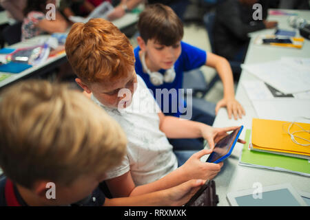 Junior high school junge Studenten mit digitalen Tabletten am Schreibtisch im Klassenzimmer Stockfoto