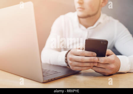 Man Hände mit Smartphone und Laptop im Inneren. Stockfoto
