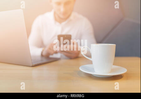 Man Hände mit Smartphone und Laptop im Inneren. Stockfoto