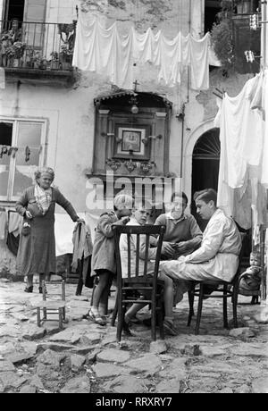 Reisen nach Neapel - Italien 1950 s-neapolitanischen Familie in einem Hinterhof in San Martino, Neapel. Eine Familie sitzt im Hof am Tisch in Neapel, Italien. Foto Erich Andres Stockfoto