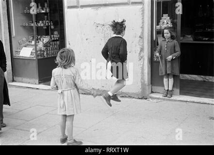 Italienisch - Italien, Italia, 1950, Rom, Roma, Kind, Kinder, Mädchen, Mädchen, Netzkabel, Springen, Ragazza, ragazze, Corda, saltellare, Gasse, stradina Italien, Rom. 1950, Mädchen beim Seilspringen auf der Straße Stockfoto