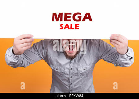 Ein Mann hält ein Plakat mit der Aufschrift mega Verkauf, ausdrucksstarken Shouts und einladenden Käufer Stockfoto
