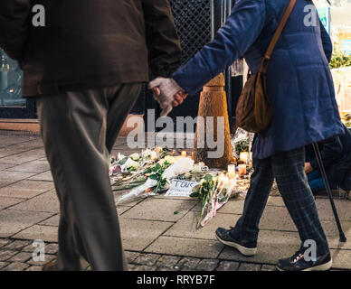 Straßburg, Frankreich - Dec 13, 2018: Senior paar Hand in Hand gehen in der Nähe von Trauer auf die Rue des Orfevres eine Mahnwache mit mehreren Kerzen Blumen und Meldungen für die Opfer von terroristischen Cherif Chekatt am Weihnachtsmarkt zu besuchen Stockfoto