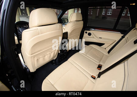 Auto innen. Einrichtung in Creme Farben Leder der Prestige luxuriöses, modernes Auto. Schwenkbares Display für Rücksitze Passagier mit media control panel Stockfoto