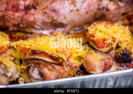 Appetitliche leckere Kalorienarme Diät juicy Hähnchenschenkel gewürzt mit Tomate und bestreut mit geriebenem Käse überbacken im Ofen braten im eigenen Saft Stockfoto