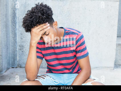 Traurig und armen afrikanischen amerikanischen Jungen erwachsenen Mann im Freien im Sommer Stockfoto