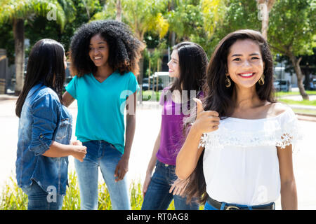 Asiatische Frau, Daumen mit einer Gruppe von Freundinnen draußen im Sommer in der Stadt Stockfoto