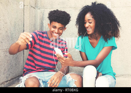 African American junger Erwachsener Paar liebt Musik im Freien im Vintage Retro Look. Stockfoto