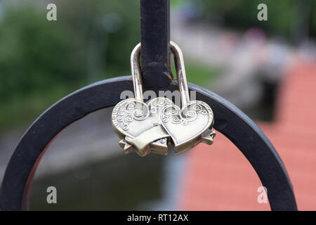 Schloss in Form von zwei Herzen ist auf der Brücke befestigt. Stockfoto