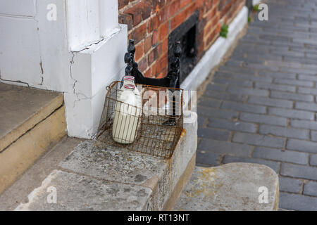 Zwei Flaschen Milch und einem Viktorianischen boot Abstreifer auf eine Haustür in St. Albans, Hertfordshire, England Stockfoto