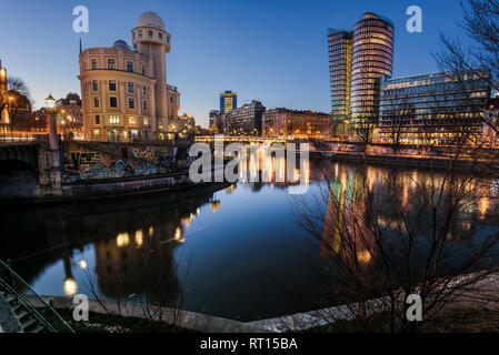 Wien, Österreich, 29. Dezember 2017. Abendlicher Blick des Wienflusses mit Beleuchtung und beleuchtete moderne Architektur Gebäude im Wasser wider. Wiener Stockfoto