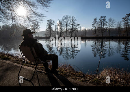 27. Februar 2019, Nordrhein-Westfalen, Dortmund: Ein angler sitzt in der Morgensonne an der Ruhr. Foto: Bernd Thissen/dpa Stockfoto