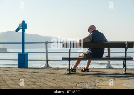Aberystwyth Wales UK Mittwoch, den 27. Februar 2019. UK Wetter: die Leute am Strand und der Promenade in Aberystwyth am Morgen die meisten sensationell heiß und sonnig, 'Winter' Wetter, während es dauert. Das Wetter Prognose zu starten ab morgen zu verschlechtern, mit mehr typische windig und kühler Anfang März Foto erwartet: Keith Morris/Alamy leben Nachrichten Stockfoto