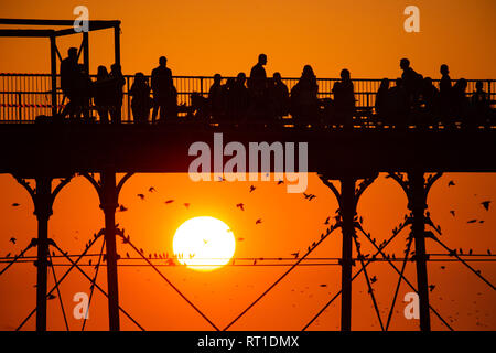 Aberystwyth Wales UK Mittwoch, den 27. Februar 2019. UK Wetter: Menschen am Meer Aberystwyth, wie die Sonne, die die meisten der sensationell heiß und sonnig, 'Winter' Wetter, während es dauert. Das Wetter Prognose zu starten ab morgen zu verschlechtern, mit mehr typische windig und kühler Anfang März Foto Keith Morris/Alamy Live Nachrichten erwartet Stockfoto