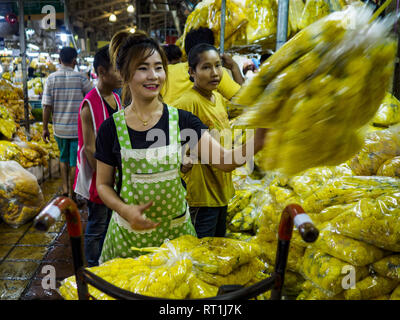 Bangkok, Bangkok, Thailand. 27 Feb, 2019. Eine Frau Stapel ringelblume Girlanden in der Bangkok Blumenmarkt. Bangkok, eine Stadt von etwa 14 Millionen, ist berühmt für seine rauhe Nachtleben. Aber echte Nachtleben von Bangkok ist in seinen Märkten und Straße Stände, von denen viele durch die Nacht geöffnet sind. Credit: Jack Kurtz/ZUMA Draht/Alamy leben Nachrichten Stockfoto