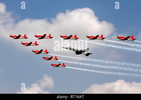 Das PC-7 Team Kunstflug Team der Schweizer Luftwaffe, Flypast in Formation mit einer F-18C Hornet Jet der SAF. Stockfoto