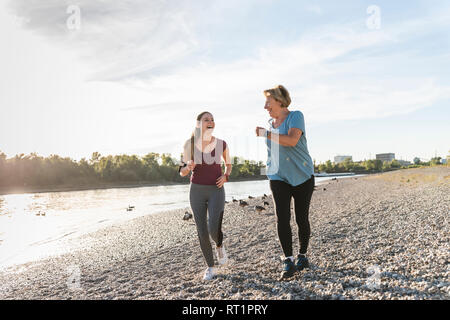 Enkelin und Oma Spaß, Joggen am Fluss Stockfoto