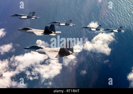 Vier F/A-18 Hornissen aus marinen Flugzeuge Group (MAG) 11, 3. Marine Flugzeugflügel (MAW), im Formationsflug über der südlichen Küste von Kalifornien fliegen mit zwei F-22 Raptors aus 3 Operations, Elmendorf Air Force Base, Alaska, Feb 6. Der Flug gedachten gemeinsame Ausbildung während der Übungen Winter Fury2019 und Patriot Grizzly2019, die auf gemeinsame Groß-force Tactical Air Integration gegen simulierte High-End-Luft-zu-Luft-und-Bedrohungen konzentrieren, weitere honen Marine und Luftwaffe 4. und 5. Generation, Taktiken und Interoperabilität erreicht. Stockfoto