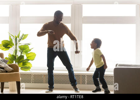 Happy afrikanischen Vater und Kind Sohn tanzen im Wohnzimmer. Stockfoto