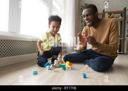 Glückliche freudige afrikanischen Vater und Kind Sohn lachen gemeinsam spielen Stockfoto