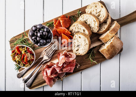 Italienische Antipasti mit mediterranen Oliven, Parmaschinken, Salami und Ciabatta Brot Stockfoto