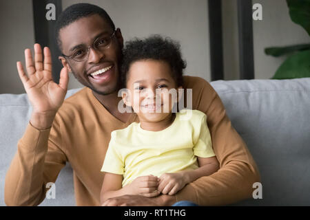 Happy afrikanischen Vater und Kind Sohn winkende Hände Aufnahme vlog Stockfoto