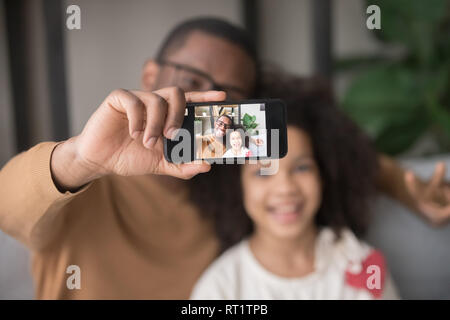 Happy afrikanischen Vater unter selfie mit Kid Tochter auf Handys Stockfoto