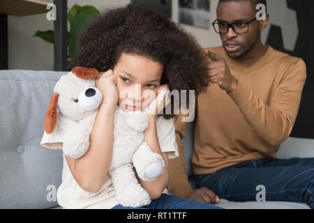 Hartnäckige afrikanisches Kind Mädchen schließen Ohren ignorieren wütend schwarz Dad Stockfoto
