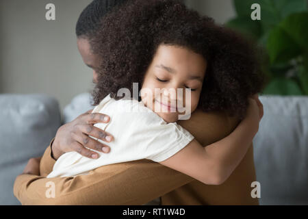 Süße Mischlinge Kind Tochter umarmt Vater Gefühl der Liebe Verbindung Stockfoto