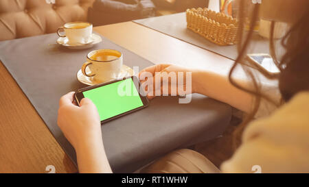 Frau mit Mobiltelefon mit Touchscreen im Cafe Stockfoto