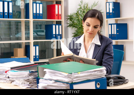 Weibliche Mitarbeiter mit zu viel Arbeit im Büro Stockfoto