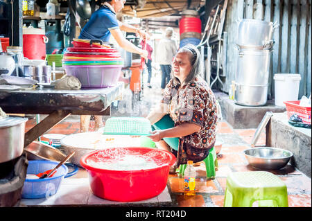 Einer alten kambodschanischen Lady scrubs Alle farbenfrohen Speisen und Eimer in Phnom Penh markt Cafe. Stockfoto