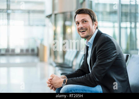 Geschäftsmann am Flughafen sitzen, warten Stockfoto