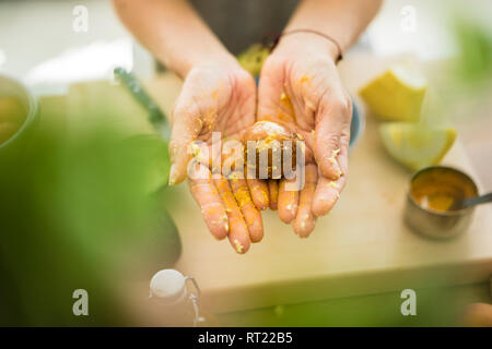 Unordentliche Hände, die Avocado Grube Stockfoto