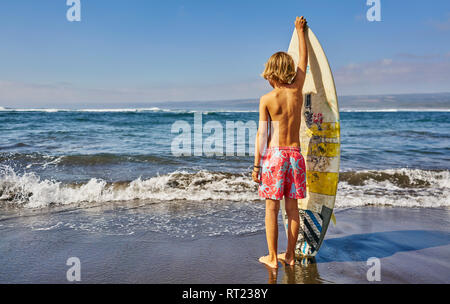 Chile, Valparaíso, Junge am Meer mit Surfbrett Stockfoto