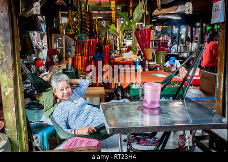 Ein kambodschanisches Wahrsagerin entspannt an Ihrem Stall warten für einen Kunden in einem langen Phnom Penh Markthalle. Phnom Penh Kambodscha. Stockfoto