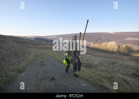 Ein Feuerwehrmann macht sich auf den Weg der Wildfire auf Saddleworth Moor in West Yorkshire in Angriff zu nehmen. Eine Fläche von rund 1,5 Quadratkilometern brannte nach Großbritannien seine heißesten Wintertag auf Aufzeichnung am Dienstag gesehen. Stockfoto