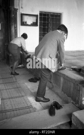 Spanien, Griechenland - Ein Mann und eine Frau ziehen sich nach dem 206 einer Kirche sterben Schuhe wieder ein, Delos, Panorama, 1950er Jahre. Ein Mann und eine Frau, die ihre Schuhe nach dem Besuch einer Kirche auf der Insel Delos, Griechenland, 1950. Stockfoto