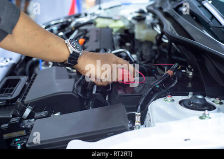 Hände von automechaniker Arbeiten in Batterie prüfen. Stockfoto