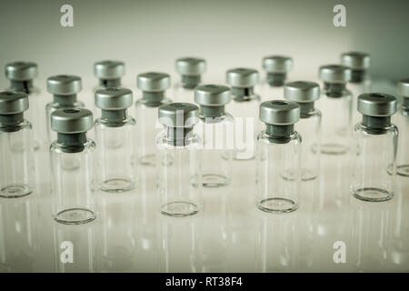 Gruppe von Impfstoff Glasflaschen auf grauem Hintergrund Stockfoto