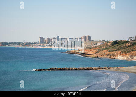 Cabo Roig felsige Küste und Mittelmeer malerische Aussicht, Dehesa de Campoamor Hochhaus Gebäude Skyline, sonnigen Tag blau klaren Himmel. Orihuela Stockfoto