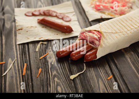 Geräucherte Wurst in pita Brot auf hölzernen Hintergrund Stockfoto