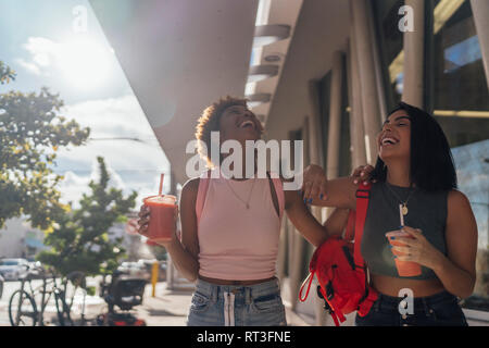 USA, Florida, Miami Beach, zwei Glückliche weibliche Freunde mit einem alkoholfreien Getränk in der Stadt Stockfoto