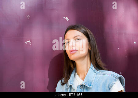 Portrait von Träumen junge Frau vor lila Hintergrund Stockfoto