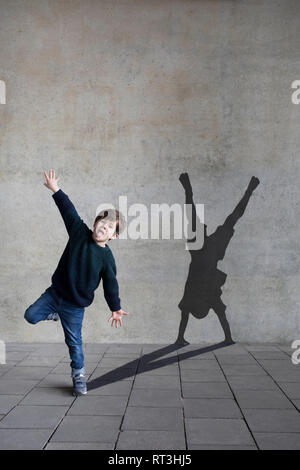 Deutschland, Duesseldorf, Portrait eines kleinen Jungen und der Schatten der Duesseldorfer cartwheeler im Hintergrund Stockfoto