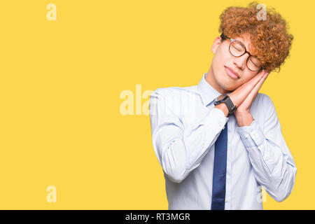Junge gut aussehender Geschäftsmann mit Afro Brille müde schlafen, träumen und mit den Händen zusammen posieren während lächelnd mit geschlossenen Augen. Stockfoto