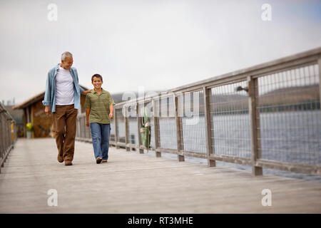 Porträt eines Jungen entlang eine Pier mit seinen ausgereiften Großvater. Stockfoto