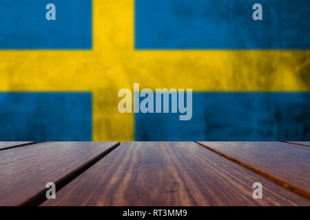 Holz Tisch Top Hintergrund und Grunge Flagge Schwedens an der Betonwand. Stockfoto