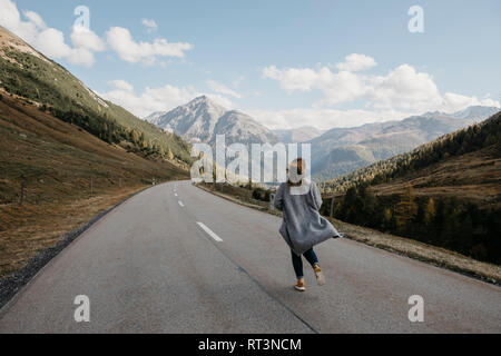 Schweiz, Engadin, Rückansicht der Frau zu Fuß auf den Berg Straße Stockfoto