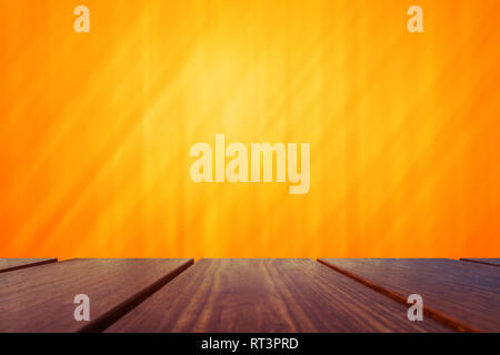 Holz Tisch und abstrakte orange hinterlegt. Stockfoto